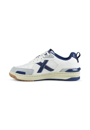 Baskets blanches et bleu marine avec côtés perforés, bout en suède gris, semelle crème et semelle extérieure en gomme, vues de côté extérieur sur fond blanc.