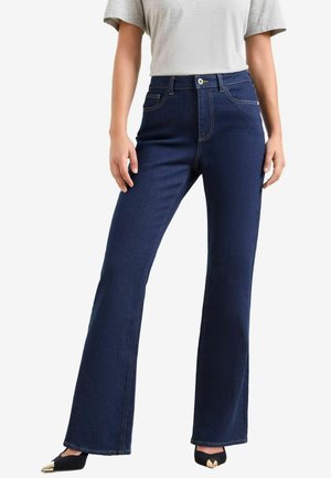 Jeans de mezclilla de campana en azul oscuro con costuras en contraste, cinco bolsillos y cierre frontal con botón. Textura suave y corte ajustado.