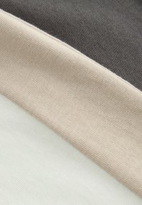 Tessuto di cotone che mostra tre strisce orizzontali: grigio scuro, beige e crema chiaro. Ogni striscia presenta una texture liscia e tessuta.