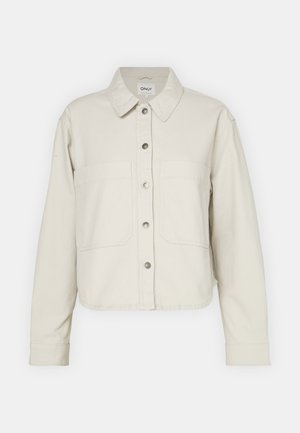 Light beige cropped jacket made of cotton, featuring a button-up front, two chest pockets, and a classic collar. Textured fabric with a relaxed fit.