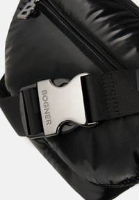Sort puffertaske med en skinnende overflade, lynlåslukning og en metallisk spænde med "BOGNER" graveret. Holdbart stof og strømlinet design.