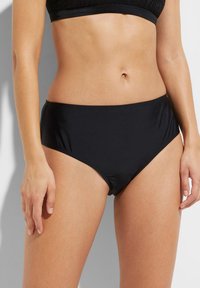 Slip bikini neri a vita alta realizzati in materiale liscio e elastico. Progettati con un taglio classico e una silhouette minimalista.