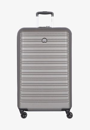 Valigia rigida argentata con strisce orizzontali, manico telescopico e quattro ruote girevoli, mostrata da un punto di vista frontale.