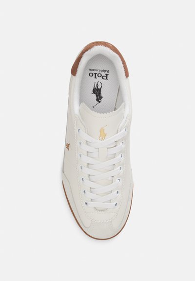 Pantof sport din piele albă cu accente maro pe călcâi, șireturi albe, logo auriu și branț texturat. Conceput pentru purtare casual, cu talpă plată din cauciuc.