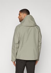 Light green waterproof jacket with a hood, featuring a textured pattern. Jacket has long sleeves and a straight hem.