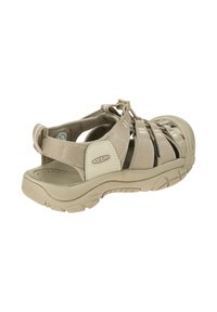 Beige sport sandal with adjustable straps, a contoured footbed, and a padded heel. Includes a rubber outsole for traction and durability.