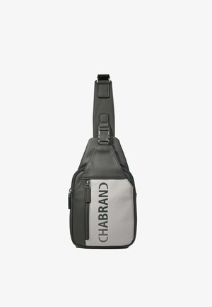Sac bandoulière noir et blanc avec poche zippée à l'avant et sangle réglable, marqué "CHABRAND" verticalement sur un panneau blanc.