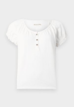 Hvit kortermet bluse med rynkede ermer, rund hals og tre brune knapper midt foran.