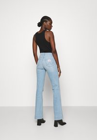 Wrangler FLARE - Calças de ganga à boca de sino - clear blue