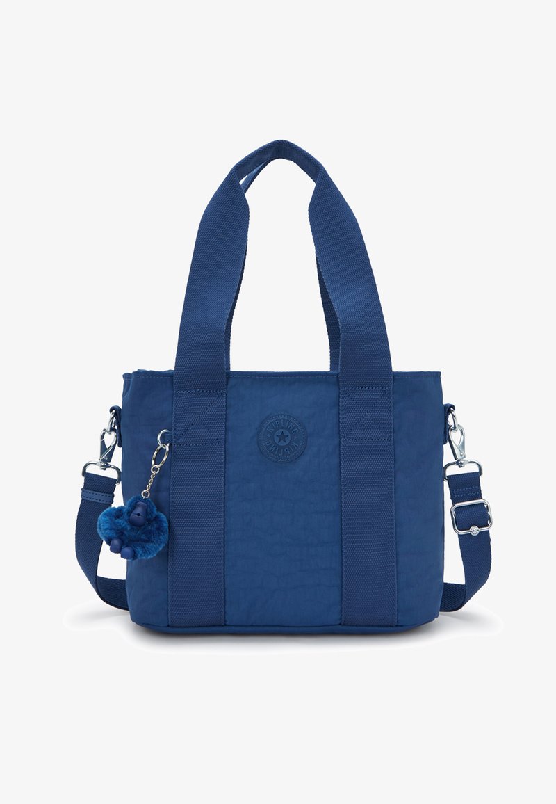 Sac fourre-tout en nylon bleu avec des anses larges, une bandoulière détachable, un patch logo rond et un petit porte-clés peluche attaché.