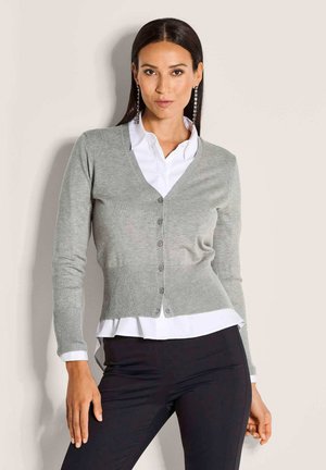 Grijze gebreide cardigan met een V-hals, knoopsluiting aan de voorkant, geribde zoom en boorden, gelaagd over een wit shirt. Glad textuur, slim fit.