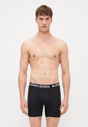 Boxers pretos com uma faixa branca apresentando o texto "BJÖRN BORG." Tecido suave, design justinho e comprimento até a coxa.