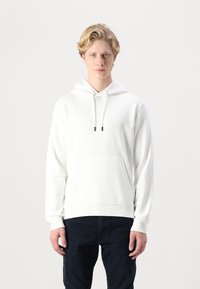 Hvid hættetrøje med lynlås og frontlomme, snor i hætten og ribkantede ærmer. Glat stofstruktur, enkelt design, parret med mørke jeans.
