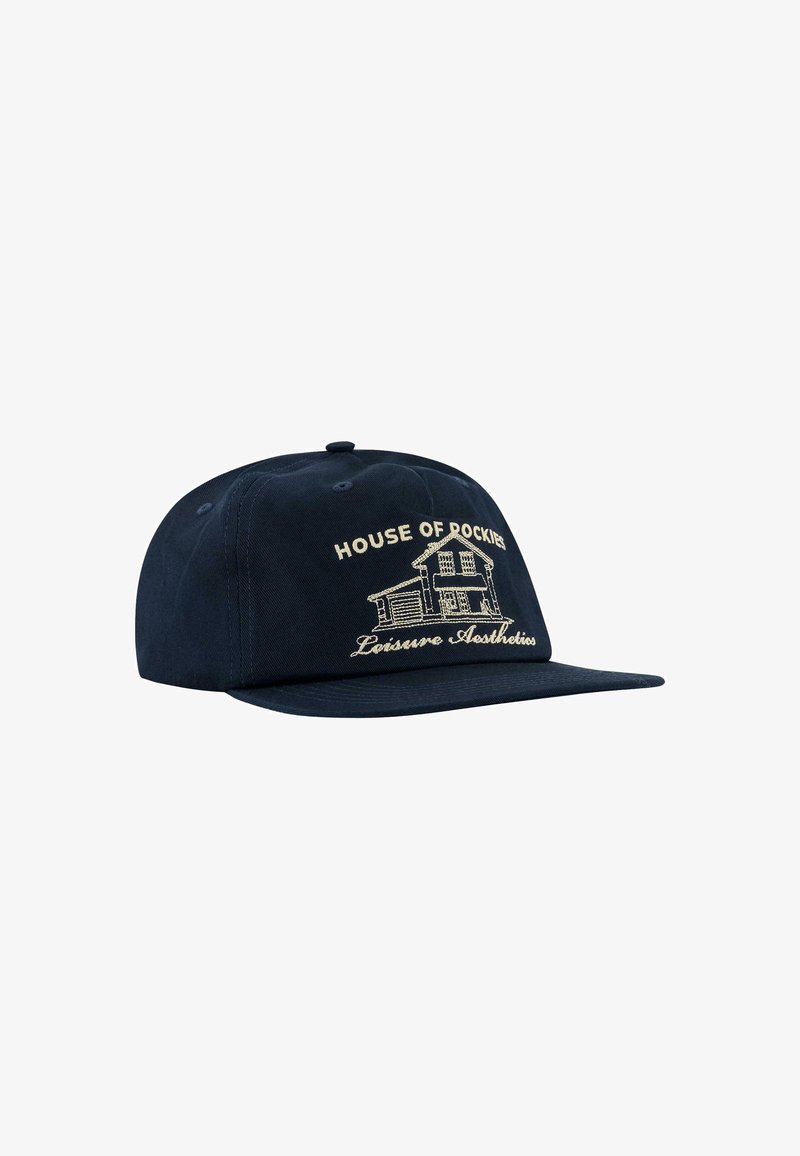 Cappellino blu navy con visiera piatta, caratterizzato da testo ricamato "HOUSE OF ROCKIES" e una grafica di una casa in beige. Realizzato in tessuto resistente.