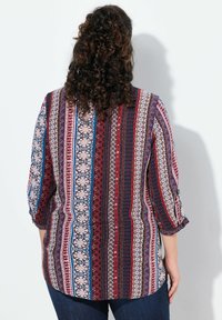 Blusa multicolore e stampata con maniche a tre quarti, caratterizzata da strisce di motivi floreali e geometrici in bordeaux, blu e crema.