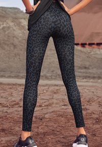 Zwarte leggings met een luipaardprint, met een aansluitend ontwerp en rekbaar materiaal. De zoom is enkel-lang en heeft een gladde textuur.