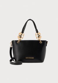 Zwarte faux leren handtas met gouden hardware, geometrische accenthandvatten, twee draagopties en een logo aan de voorkant.