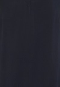 Mörkblå skjorta med en slät, mjuk textur; har en subtil V-ringning och inga mönster eller dekorationer. Enkel, minimalistisk design.