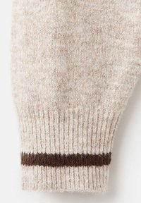 Polsino di maglione lavorato a maglia in morbida lana beige con un aspetto testurizzato e una striscia orizzontale marrone scuro nella parte inferiore.