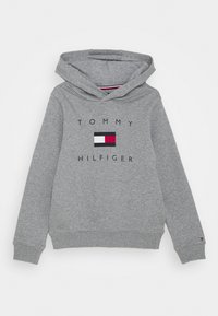 Sudadera gris con el texto "TOMMY HILFIGER" y un pequeño diseño de bandera en rojo, blanco y azul centrado en la parte delantera.