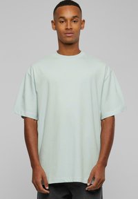 Lys mintgrønn oversized T-skjorte laget av mykt stoff. Har korte ermer, rund hals og en avslappet passform.