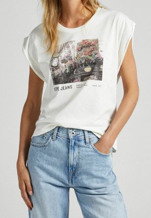 Frau trägt ein weißes ärmelloses T-Shirt mit floralem Straßenfoto und dem Schriftzug "PEPE JEANS", kombiniert mit hellblauen Jeans.