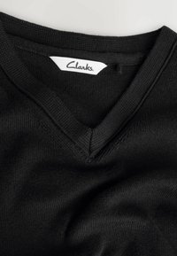 Maglione nero lavorato a maglia con scollo a V. Presenta una texture liscia e un'etichetta Clarks all'interno del colletto.