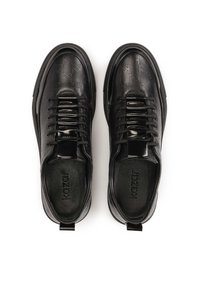 Zapatillas de cuero negro con patrón de logo en relieve, diseño de cordones, acentos brillantes y plantilla texturizada. Presentan una lengüeta en el talón.