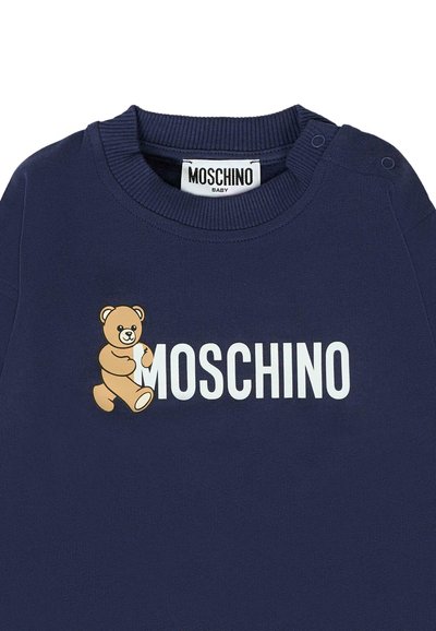 Felpa blu navy con un orso cartoon e la scritta "MOSCHINO" in bianco. Collo a costine e dettaglio a pressione sulle spalle per una facile vestibilità.