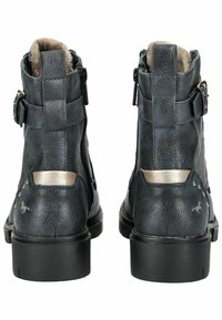 Bottines noires en cuir avec une finition texturée, accents argentés, fermeture éclair sur le côté et détails cloutés. Doublées d'un matériau doux pour plus de confort.