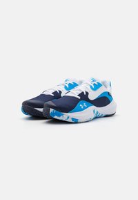 Baskets de sport bleu et blanc avec une tige texturée bleu marine, des accents contrastants et un design de semelle à motif pour une meilleure adhérence.
