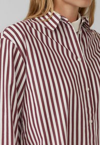 Bordeaux-rot und weiß gestreiftes Hemd mit Knopfverschluss, Kentkragen, weichem Stoff und sichtbaren Knöpfen auf der Knopfleiste.