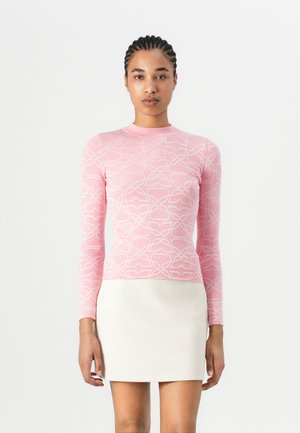 Pink long-sleeve top with a textured floral pattern, paired with a white, smooth mini skirt. The fabric appears stretchy and fitted.