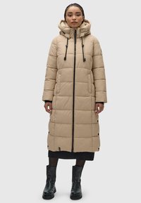 Bežinė pamušta ilga striukė su kapišonu, turinti priekinį užtrauktuką, raištelius ir snapų akcentus. Pagaminta iš lygios, izoliuotos medžiagos.