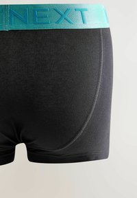 Crne bokserice s širokim, tirkiznim elastičnim pojasom s utisnutim tekstom. Glatka tkanina s kontrastnim detaljima šivanja.
