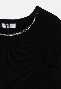 Črn rebrast pulover z okroglim ovratnikom, ki ima srebrno akcentirano rhinestone in logotip blagovne znamke na ovratniku. Gladka tekstura.
