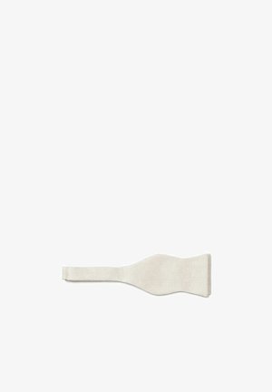 Losse beige stoffen vlinderdas liggend plat op een witte achtergrond.
