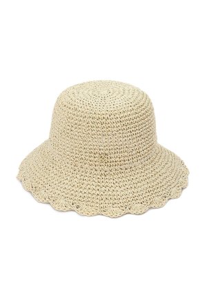 Chapeau seau beige en crochet avec un large bord légèrement ondulé.
