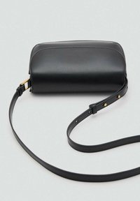 Borsa a mano in pelle nera con la parte superiore arrotondata, tracolla regolabile e dettagli in hardware dorato. Texture liscia e design minimalista.
