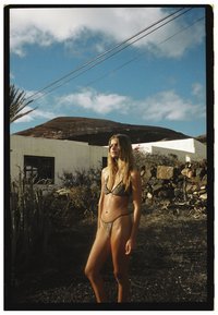 Bikini s leopardím vzorem, trojúhelníkovým vrškem a vysoce vykrojenými kalhotkami; tenké ramínka; přírodní, strukturovaná tkanina; modelka stojí na pozadí skalnaté krajiny.