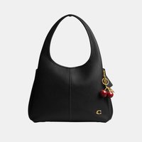 Zwarte leren schoudertas met één riem, goudkleurig "C"-logo onderaan en een rood kersenbedeltje aan de zijkant bevestigd.