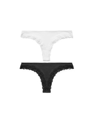 Due perizomi da donna con rifiniture in pizzo, uno bianco e uno nero, distesi su sfondo bianco.