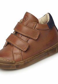 Bruna läderhögskor med två kardborreband, rundad tå, tanfärgad gummisula och marinblå mockadetalj vid hälen.