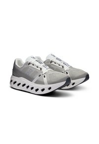 Baskets de sport grises avec une tige texturée, des lacets blancs, une semelle perforée unique et des accents noirs contrastants. Présentent un design stable et rembourré.