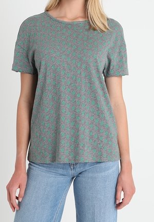 T-shirt grigio a maniche corte con motivo a pois verdi, realizzato in tessuto morbido, con scollo rotondo e vestibilità rilassata.