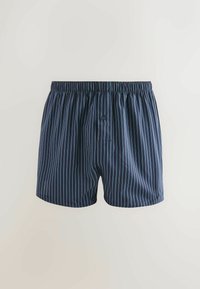 Dunkelblaue Baumwollboxershorts mit vertikalen hellblauen Streifen, ausgestattet mit einem elastischen Bund und einem einzelnen Knopfverschluss vorne.