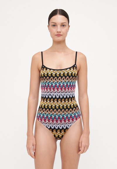 Costum de baie dintr-o singură piesă, cu bretele subțiri, bază neagră cu modele zigzag multicolore în roz, albastru, galben și alb, textură netedă.