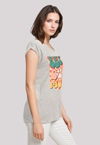 Grijze katoenen T-shirt met korte gerolde mouwen heeft een kleurrijke grafische print met een pootontwerp en speelse lettering op de voorkant.