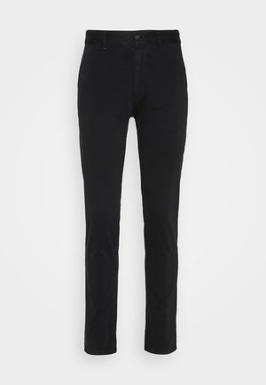 Black cotton chinos with a slim fit, featuring a standard waistband, front pockets, and a single back pocket. Smooth texture and minimal detailing.
