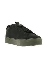 Zwarte sneaker met een glad bovenwerk, ronde neus en rubberen zool. Heeft een vetersluiting aan de voorkant en een groene gestructureerde platformzool.